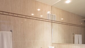 A modern bathroom with a toilet, sink, and mirror. - Hotel Globales Cala´n Bosch (Ciutadella de Menorca)