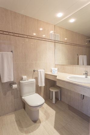 Ein modernes Badezimmer mit Toilette, Waschbecken und Spiegel.