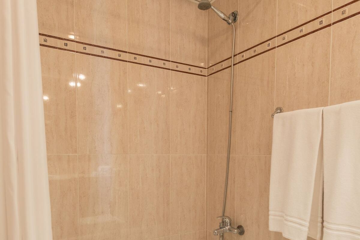 Ein modernes Badezimmer mit Badewanne, Dusche und Fliesen.