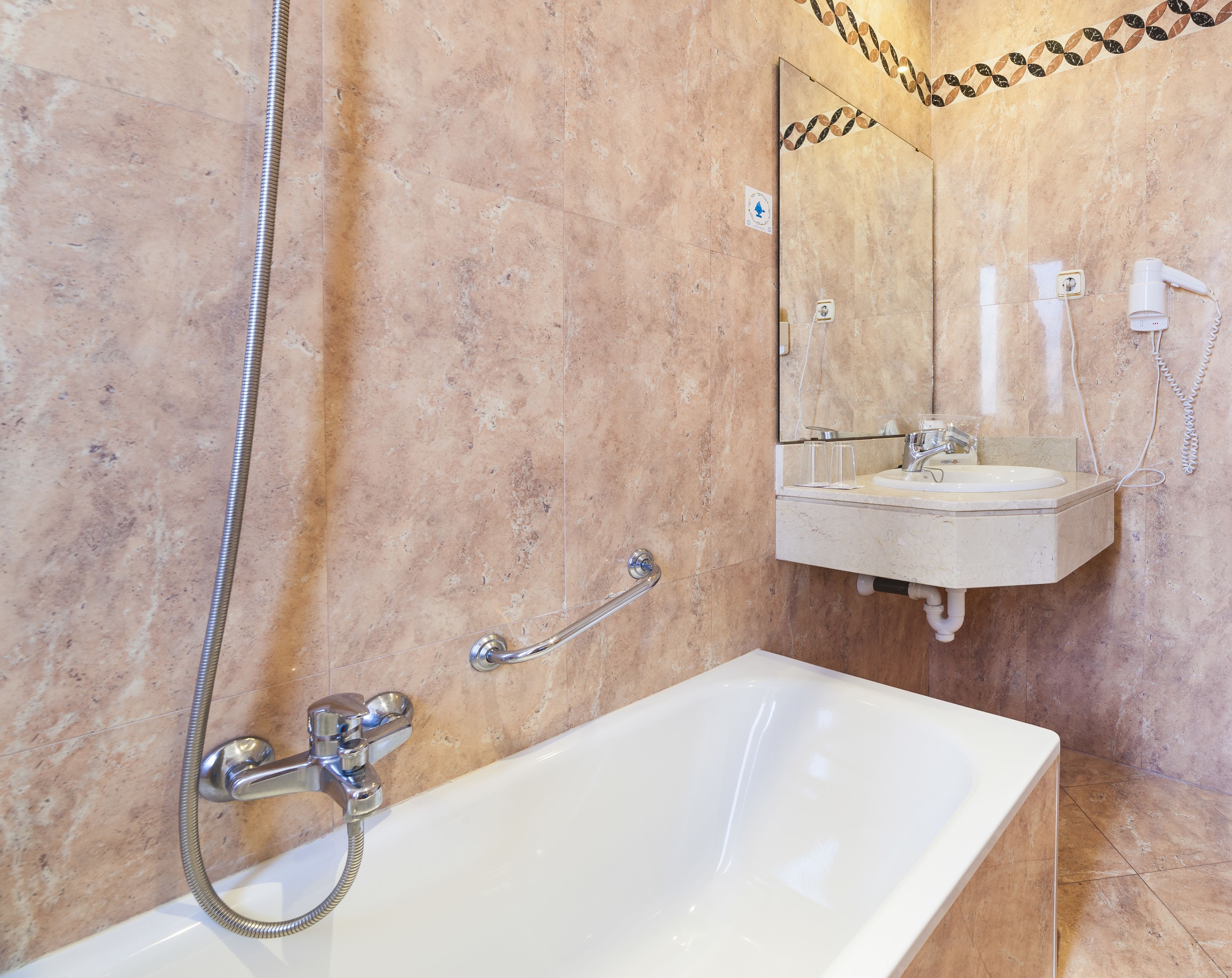 Un baño con bañera, lavamanos y espejo.