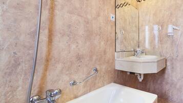 Un baño con bañera, lavamanos y espejo.
