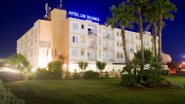 Ein mehrstöckiges Hotel mit Balkonen und einer gut beleuchteten Fassade.