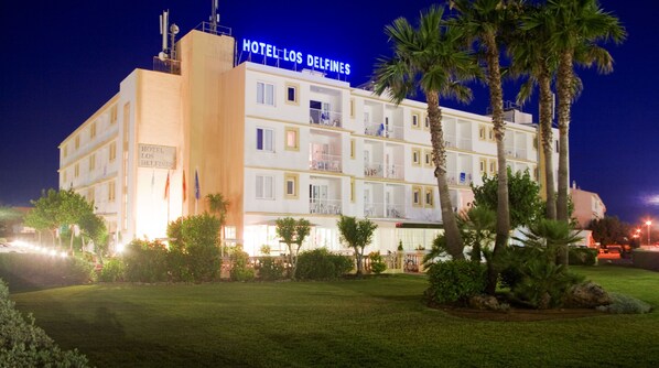 Un hôtel à plusieurs étages, doté de balcons et d’une façade bien éclairée.