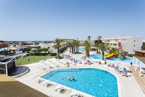Ein Poolbereich mit großem Pool, Liegestühlen und einer Wasserrutsche.
