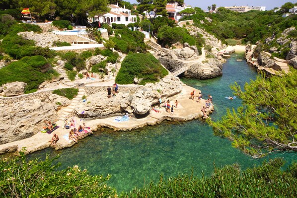 A coastal area with clear water, rocky formations, and people enjoying the scenery.