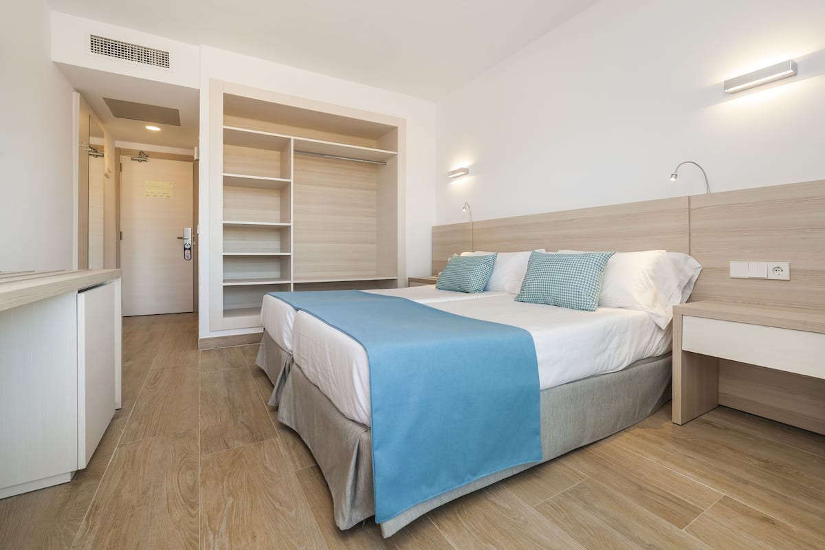 Une chambre à coucher comprenant un lit, une table de chevet et une armoire intégrée.