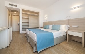 A bedroom with a bed, bedside table, and a walk-in closet. - Globales Mimosa (Calvia)