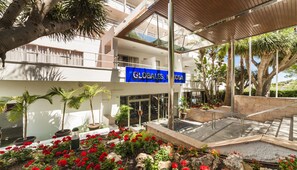A hotel with a modern design, featuring a central atrium with a glass ceiling, multiple balconies, and a variety of indoor plants. - Globales Mimosa (Calvia)