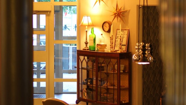 A warmly lit room with a round table, a chair, and a decorative star on the wall.