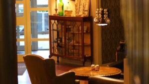 A cozy living room with a leather sofa, a round coffee table, and a decorative lamp.