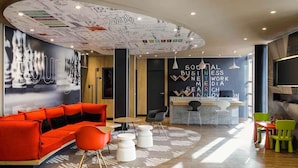 A modern interior with a red sofa, a bar area, and a ceiling with a map design.
