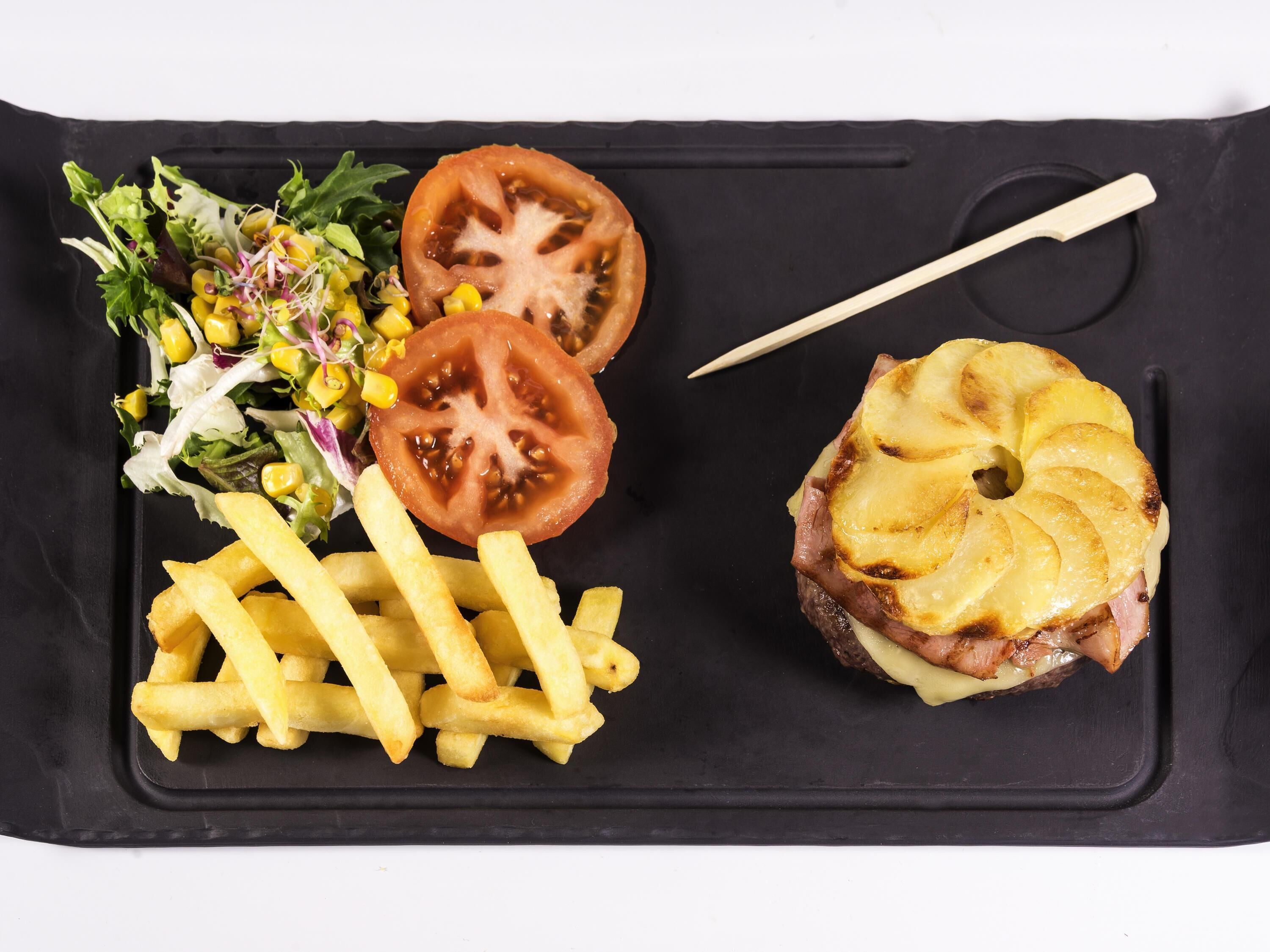 Un plateau-repas comprenant un hamburger, des frites et une salade.