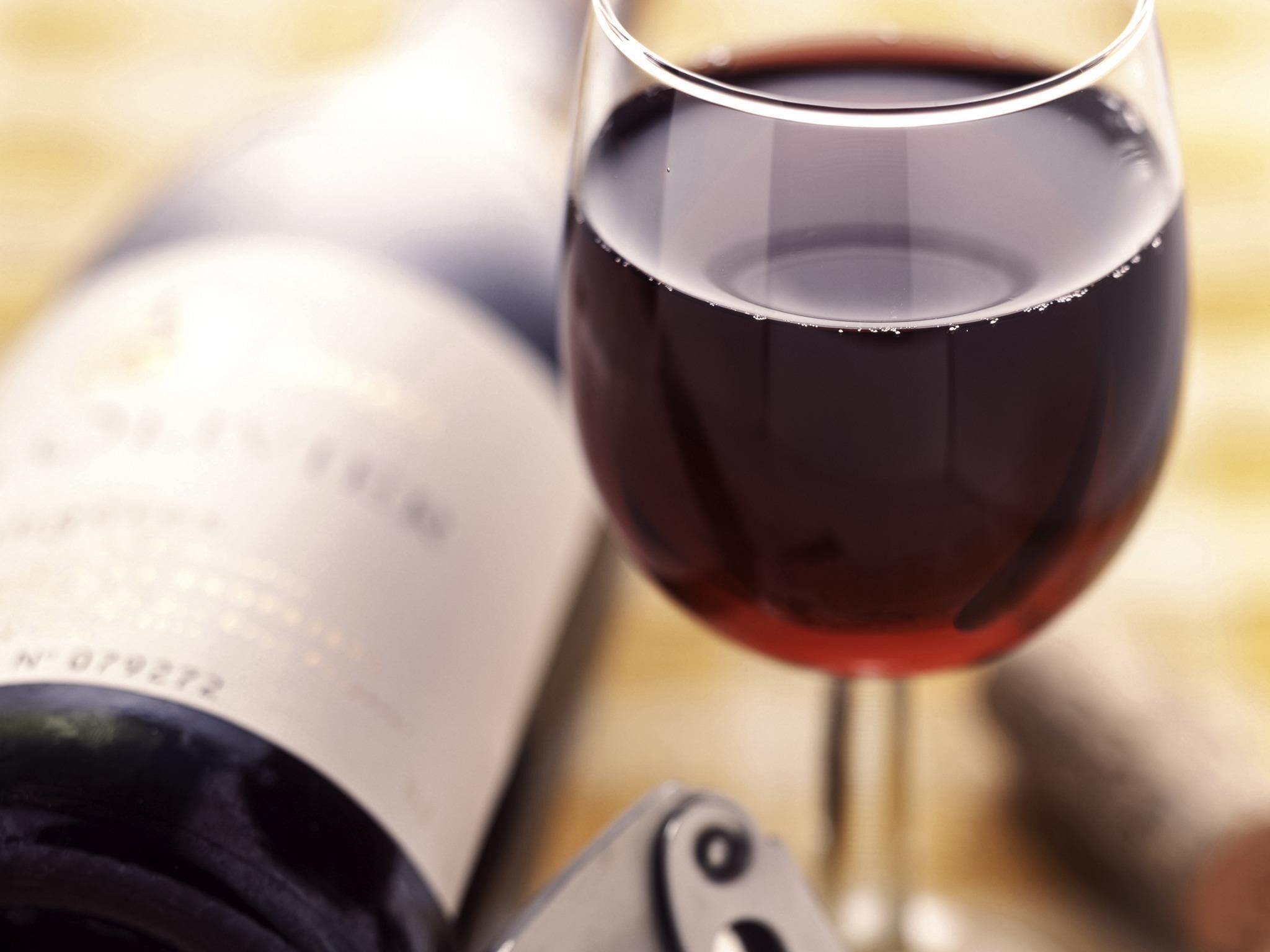 A wine bottle and glass on a table.
