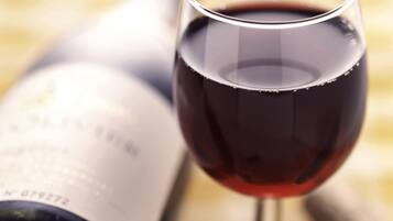 A wine bottle and glass on a table.