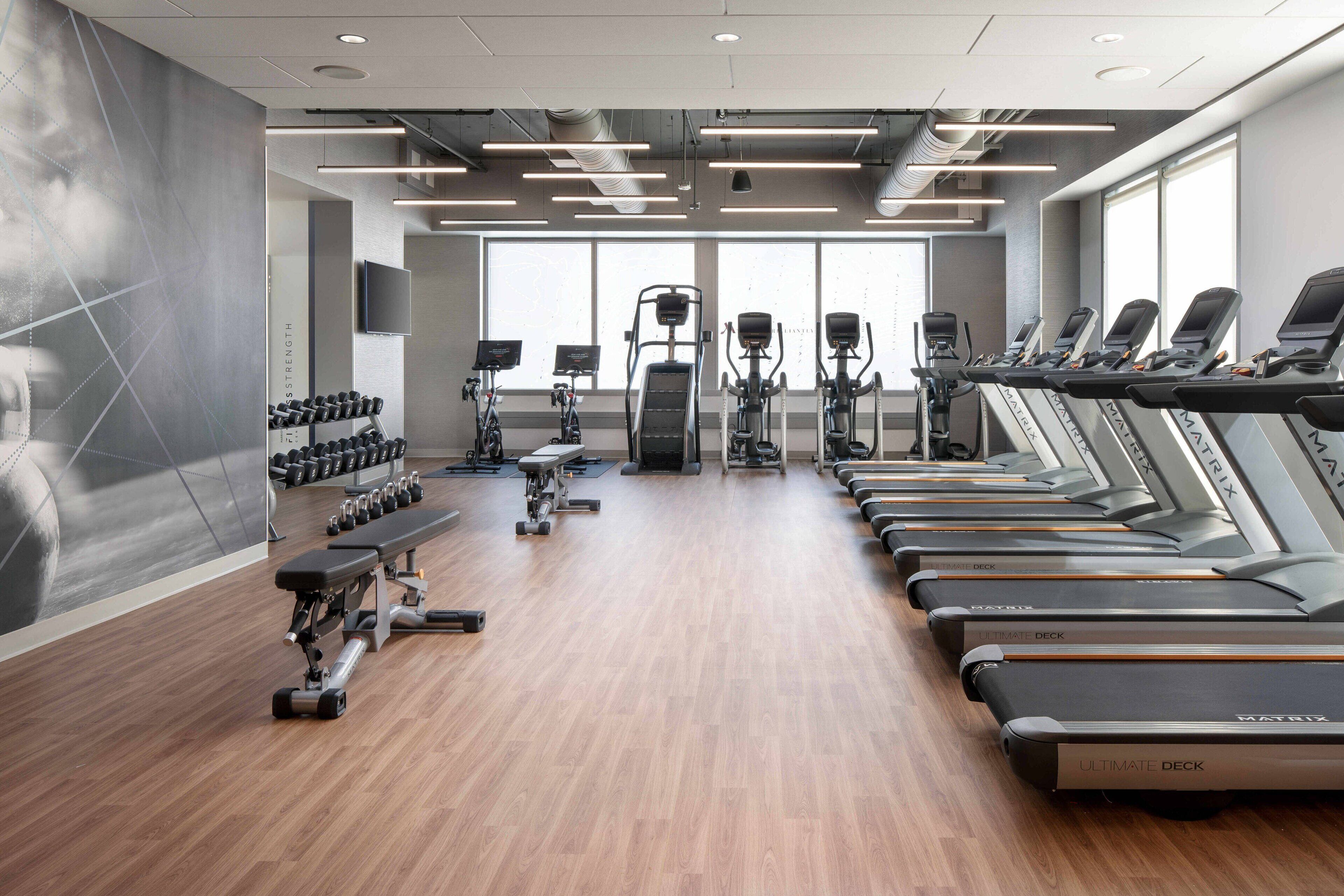Una palestra attrezzata con tapis roulant, manubri e macchinari per l'allenamento con i pesi.