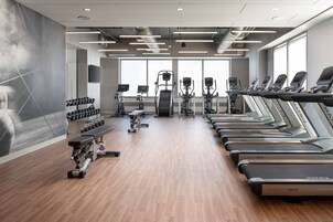Una palestra attrezzata con tapis roulant, manubri e macchinari per l'allenamento con i pesi.