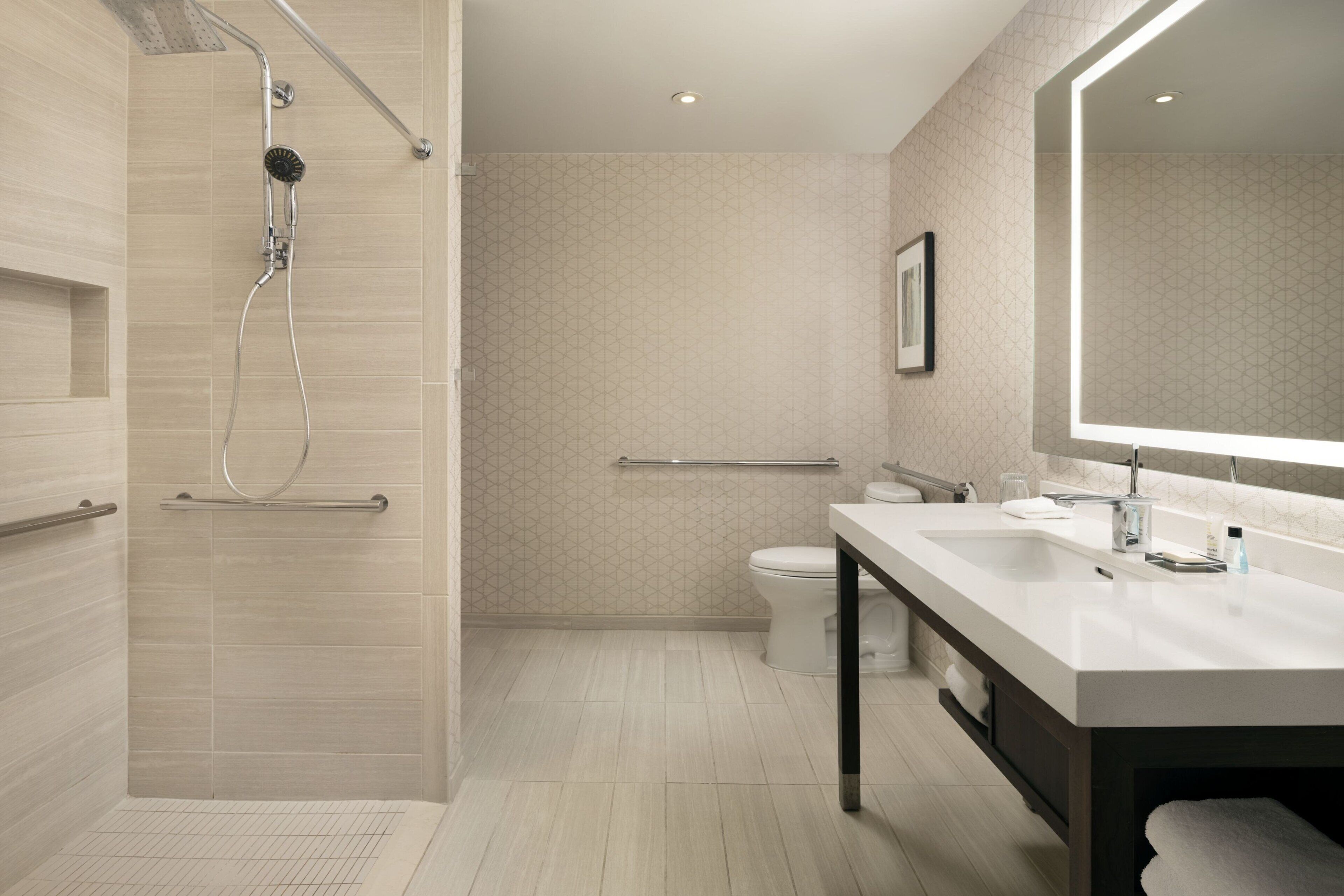 A modern bathroom with a shower, toilet, and vanity.