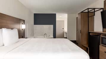 Une chambre d’hôtel avec un grand lit, une armoire en bois, une télévision et un mur en marbre.