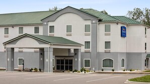 A hotel with a covered entrance, multiple windows, and a sign indicating it is part of the Baymont St. Wyndham hotel chain. - Baymont by Wyndham La Grange KY Southeast (La Grange)