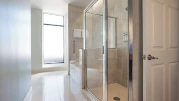 Un baño moderno con cabina de ducha de vidrio, inodoro y lavamanos.