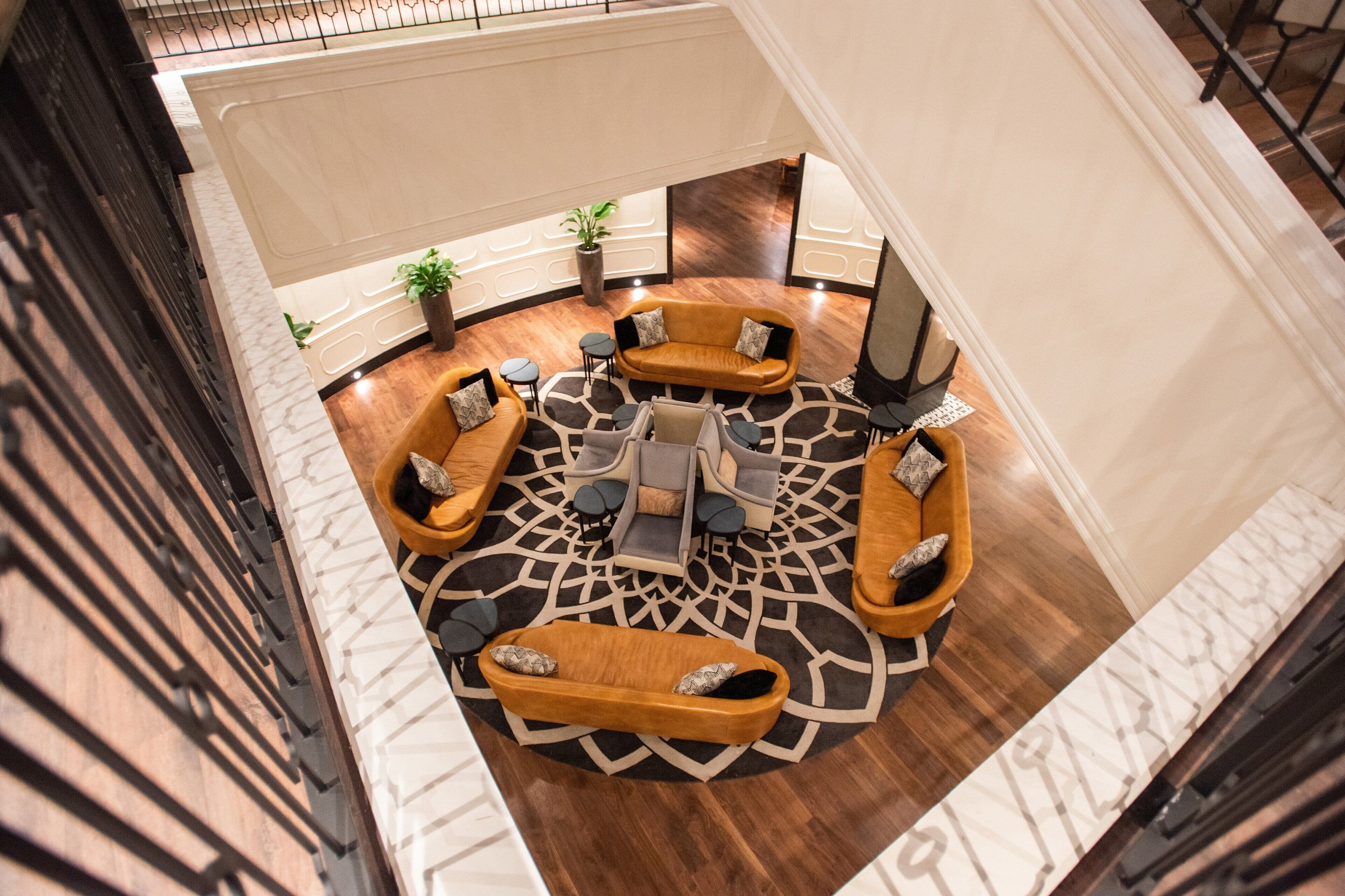 Amplia sala circular con diversas opciones de asiento, incluyendo sofás y sillones, organizados alrededor de una mesa de centro.