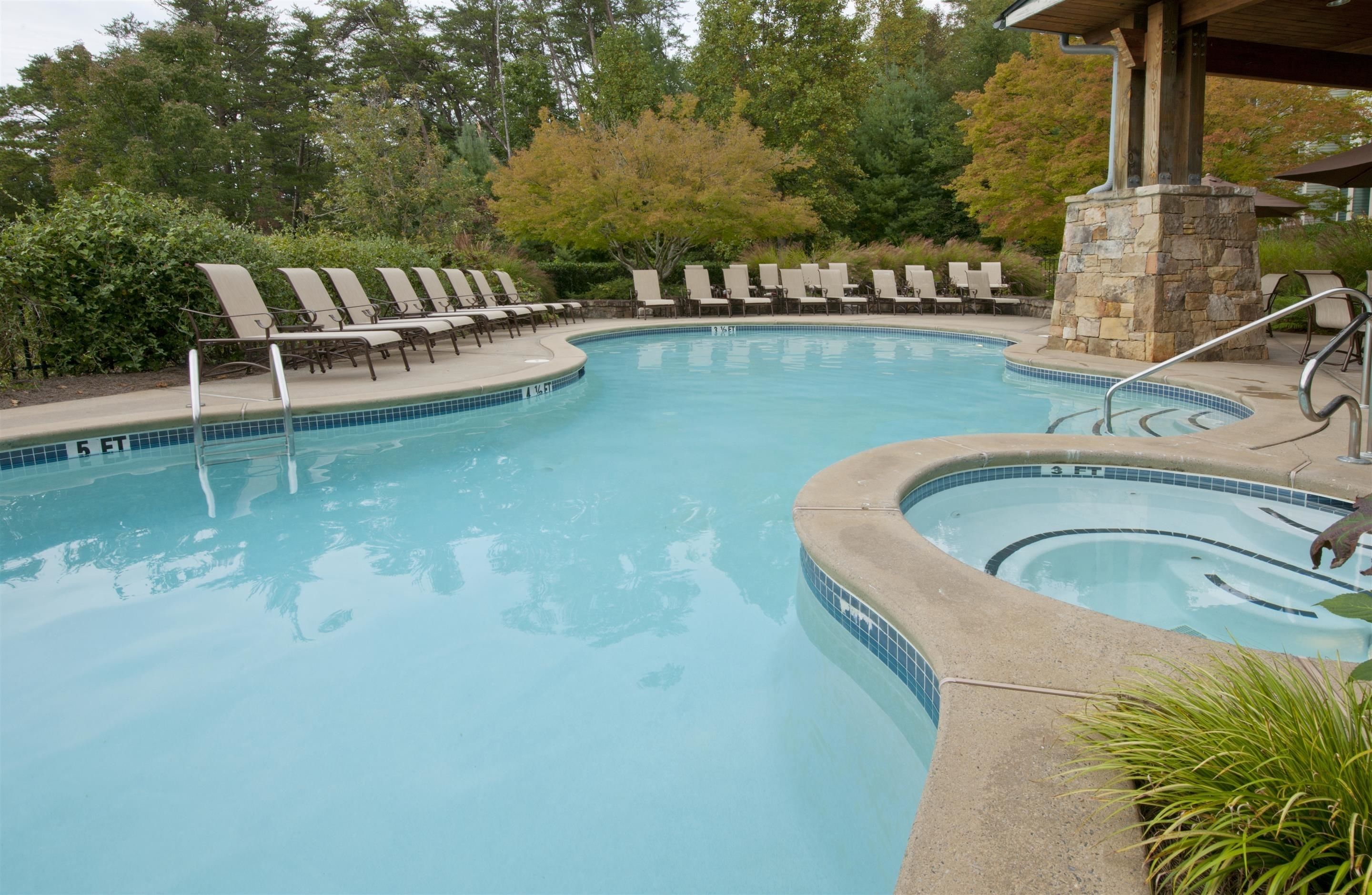 A swimming pool with lounge chairs and a stone structure.