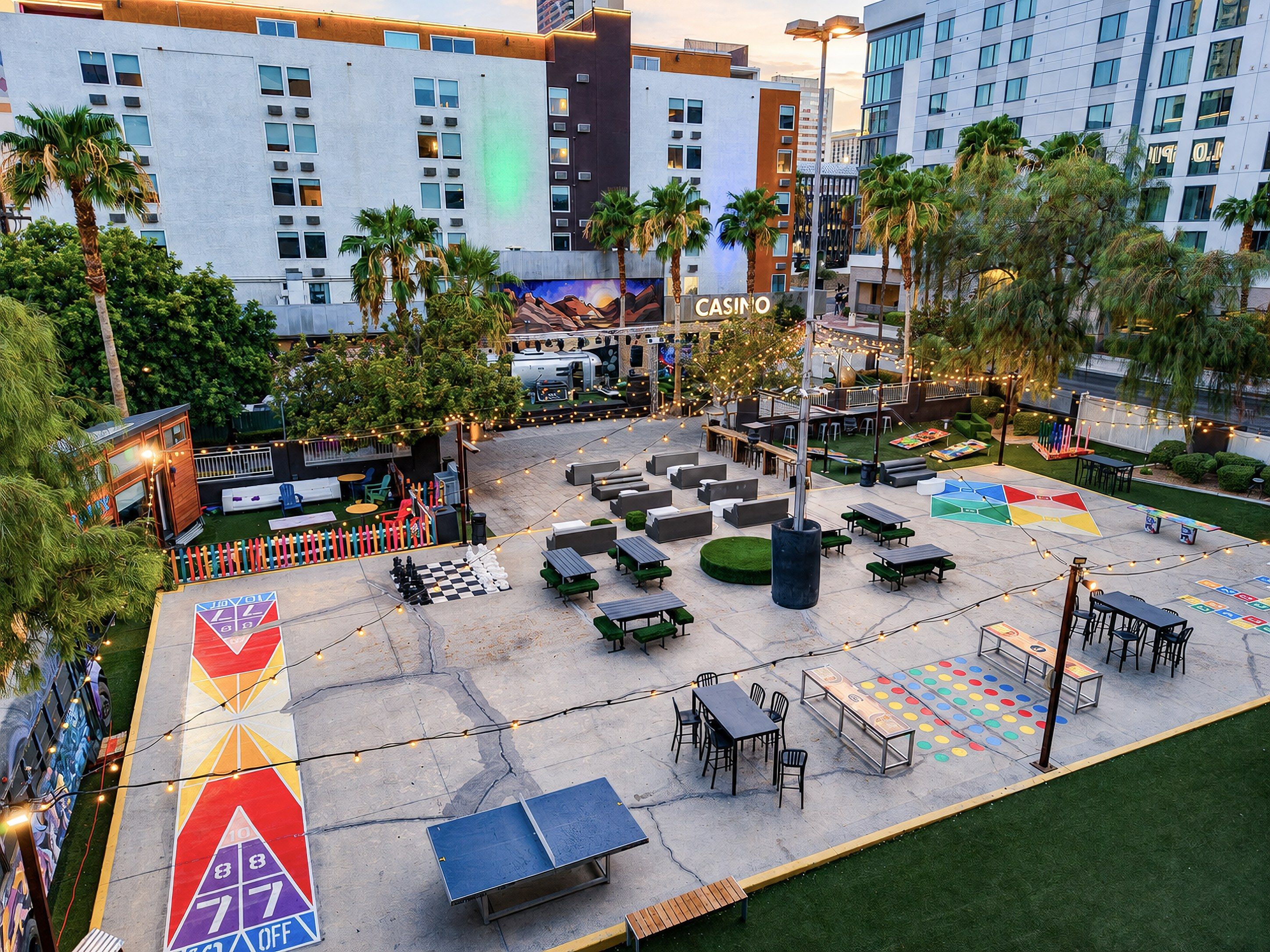 An outdoor casino area with tables, chairs, and a large checkered game table.