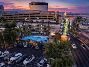 Un hôtel doté d'une piscine, d'un parking et d'une enseigne lumineuse au néon.