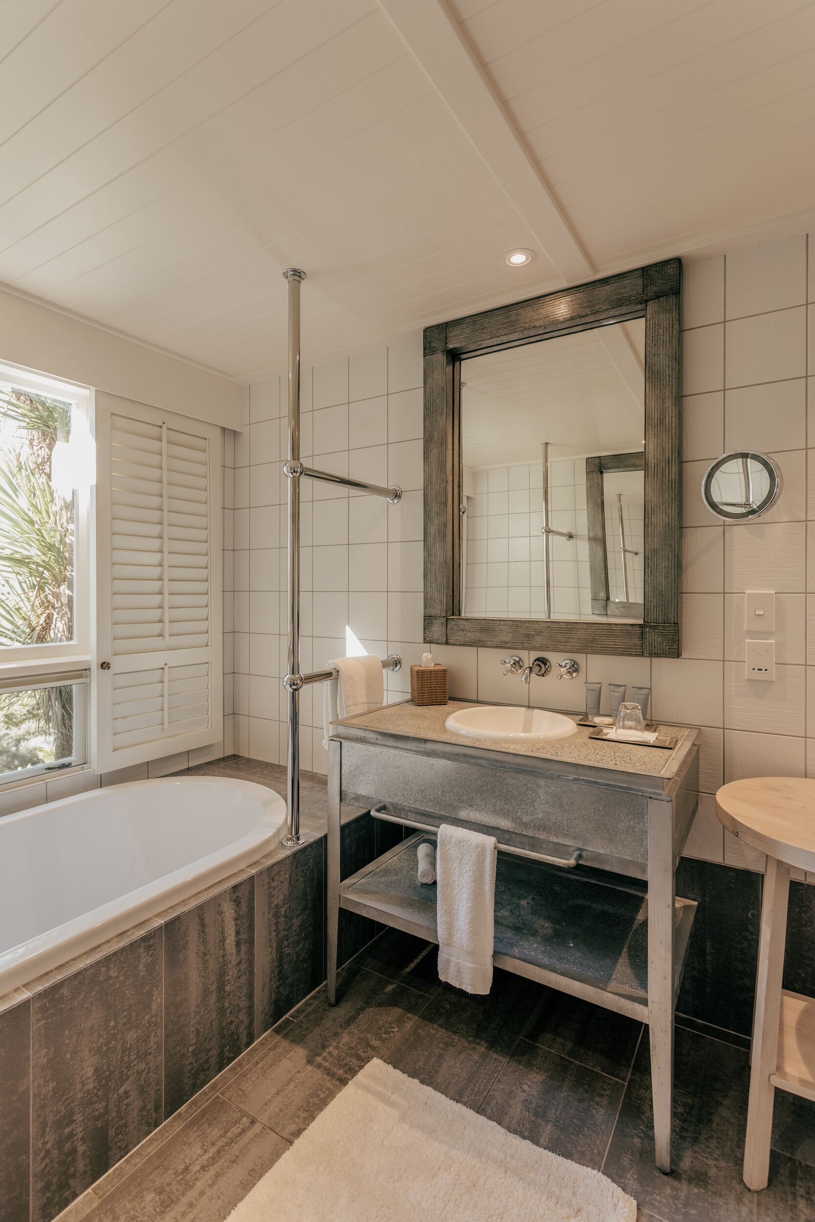 A modern bathroom with a bathtub, a sink, and a mirror.