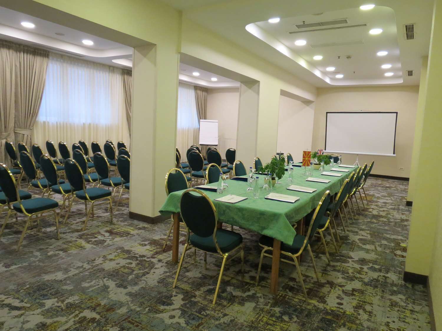 Une salle de conférence équipée d’une longue table, de chaises et d’un écran de projection.