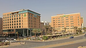 A Holiday Inn hotel with a modern design, featuring multiple floors and a prominent glass facade.