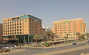 A Holiday Inn hotel with a modern design, featuring multiple floors and a prominent glass facade.