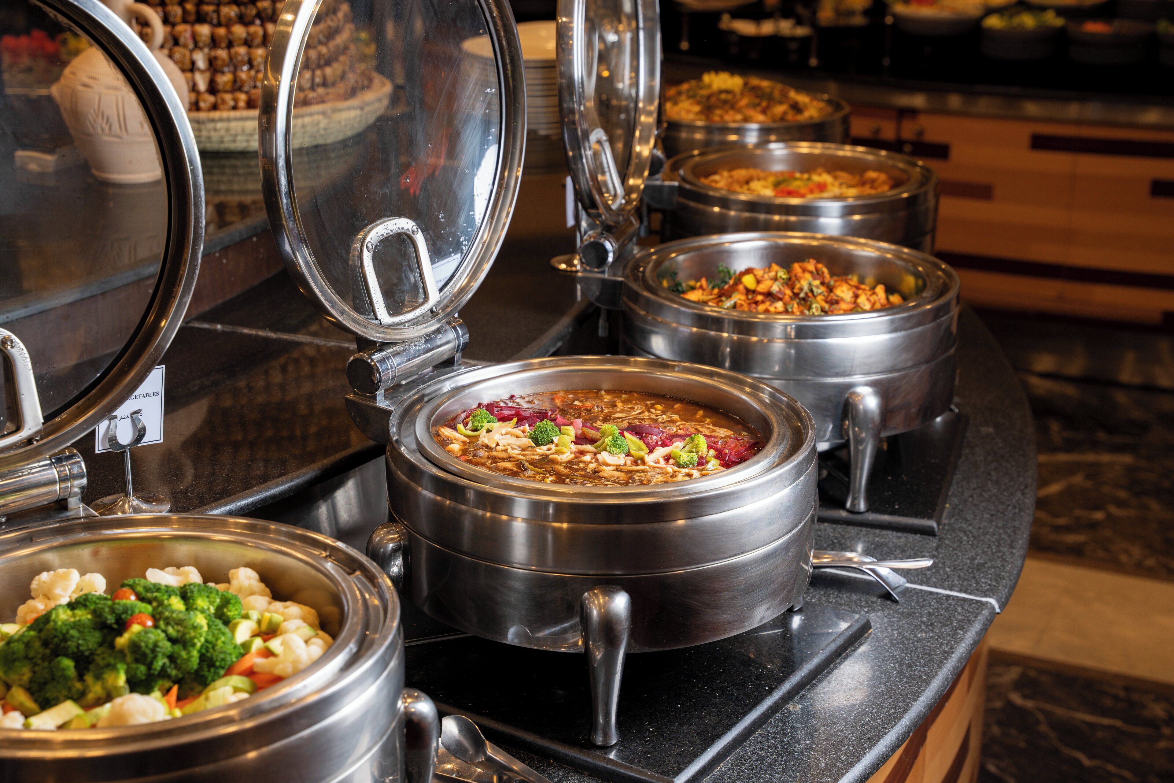 Ein Buffet mit verschiedenen Speisen in Metallbehältern.