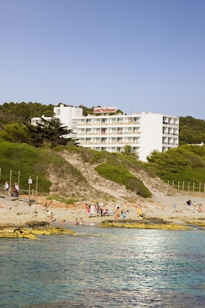 Un hotel con varios balcones y una playa al frente.