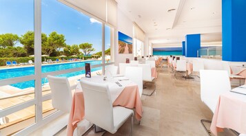 Un restaurante con vistas a una piscina y una playa.