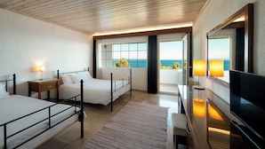 A hotel room with two beds, a TV, a desk, and a large window with a view of the sea. - Canvas by Mitsis Alexander the Great (Kassandra)