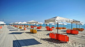 Plage privée, cabines (en supplément), chaises longues, parasols