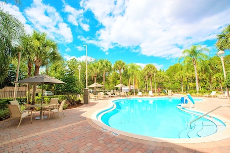 Una piscina al aire libre, sillones reclinables de piscina