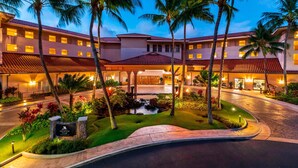 A hotel with a central courtyard, palm trees, and a small water feature. - Marriott's Waiohai Beach Club (Koloa)