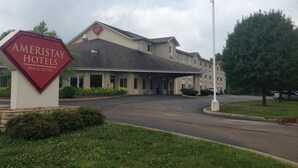 Un edificio de Ameristay Hotels con un letrero, una zona de estacionamiento techada y vista a la calle.