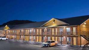 A multi-story motel with a brick facade, multiple balconies, and a parking lot. - Super 8 by Wyndham Whites Creek/ Nashville NW Area (Whites Creek)
