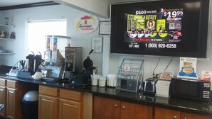 A breakfast counter with a menu board, a coffee machine, and various kitchen appliances.