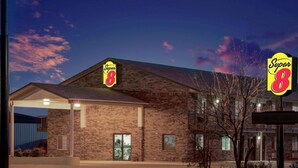 A Super 8 hotel with a brick facade, large windows, and a covered parking area.