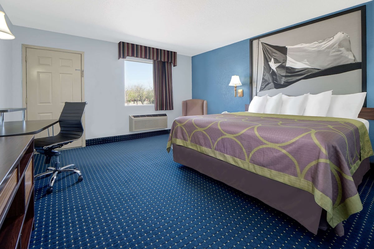 Escritorio, cortinas blackout y tabla de planchar con plancha