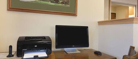 Ein Holztisch mit einem Desktop-Computer, einem Drucker und einer Tastatur.
