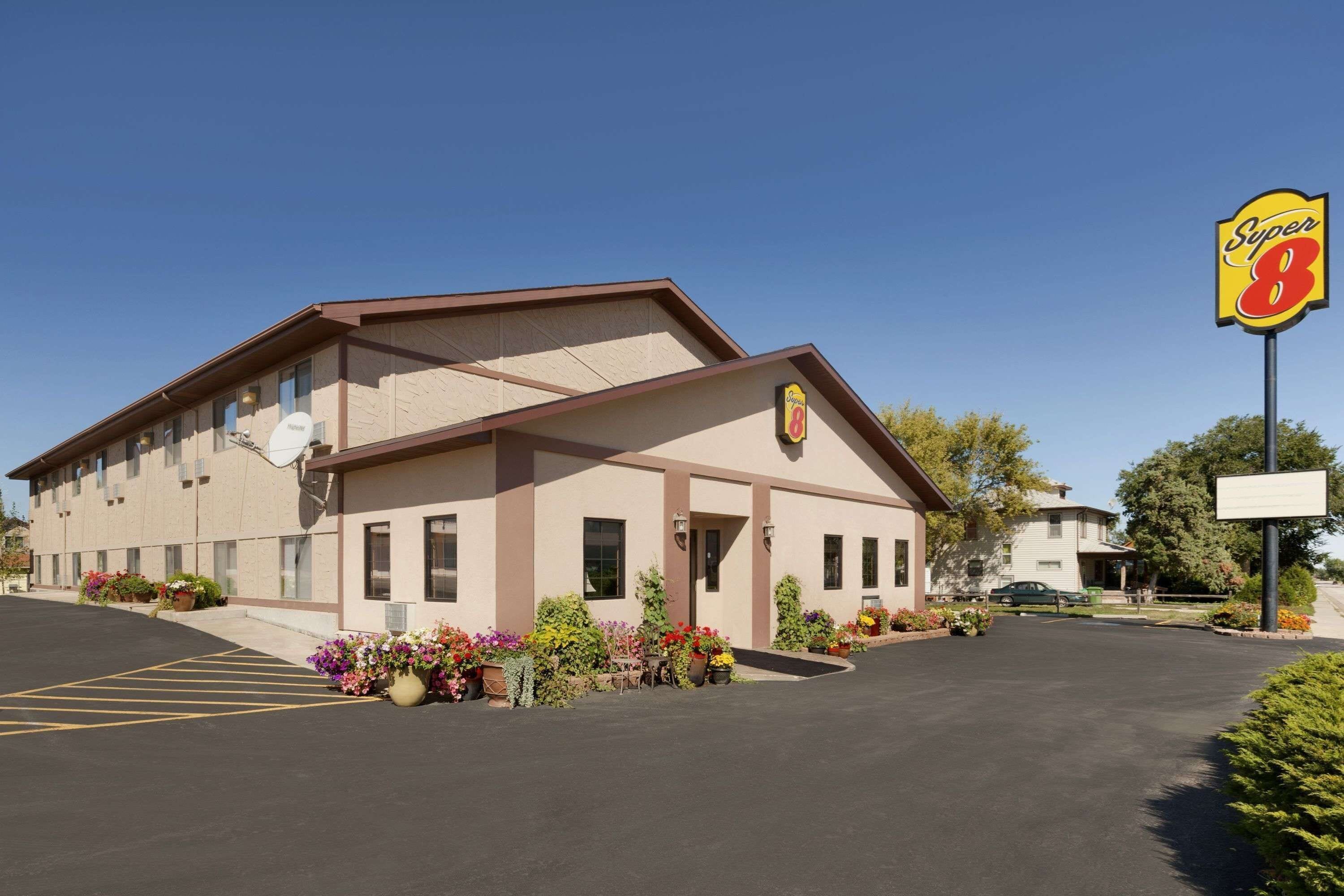A Super 8 motel with a parking lot, exterior signage, and potted plants.