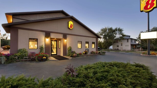 Ein Super 8 Motel mit modernem Design, einem gut beleuchteten Eingang und einem Parkplatz.