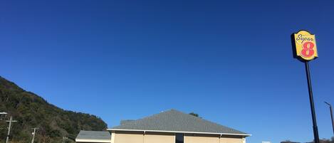 A Super 8 motel with a two-story building, a parking lot, and a mountainous backdrop.