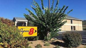 Une enseigne d’hôtel Super 8, avec un ciel bleu clair en arrière-plan.