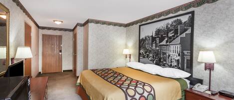 Ett hotellrum med en säng, sänglampor, ett skrivbord och en stor, inramad tavla på väggen.
